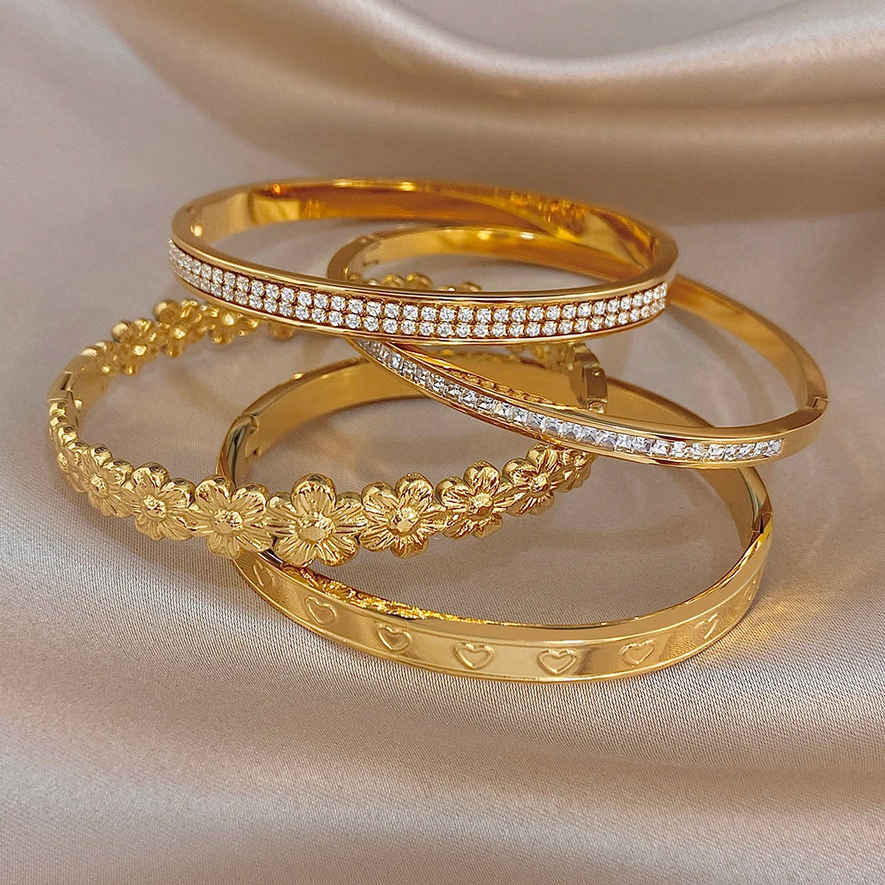 Gold tone stacked cuff bangles with rhinestone rows and floral heart motif