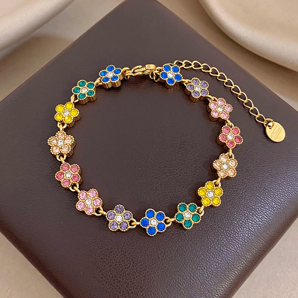 Gold-tone bracelet with pastel flower zircon beads in blue, pink, yellow, and purple