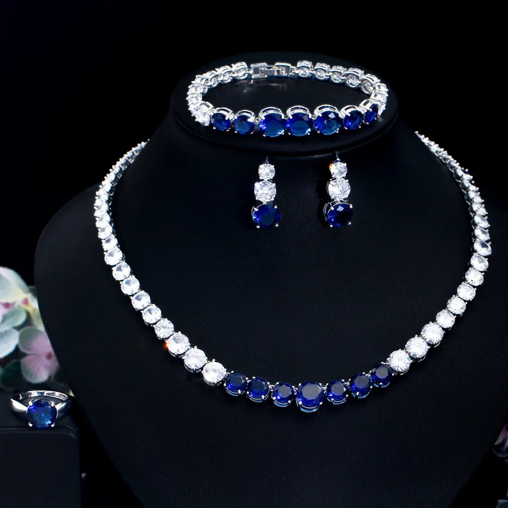 Blue cubic zirconia tennis jewelry set on display: necklace, bracelet, ring, and earrings