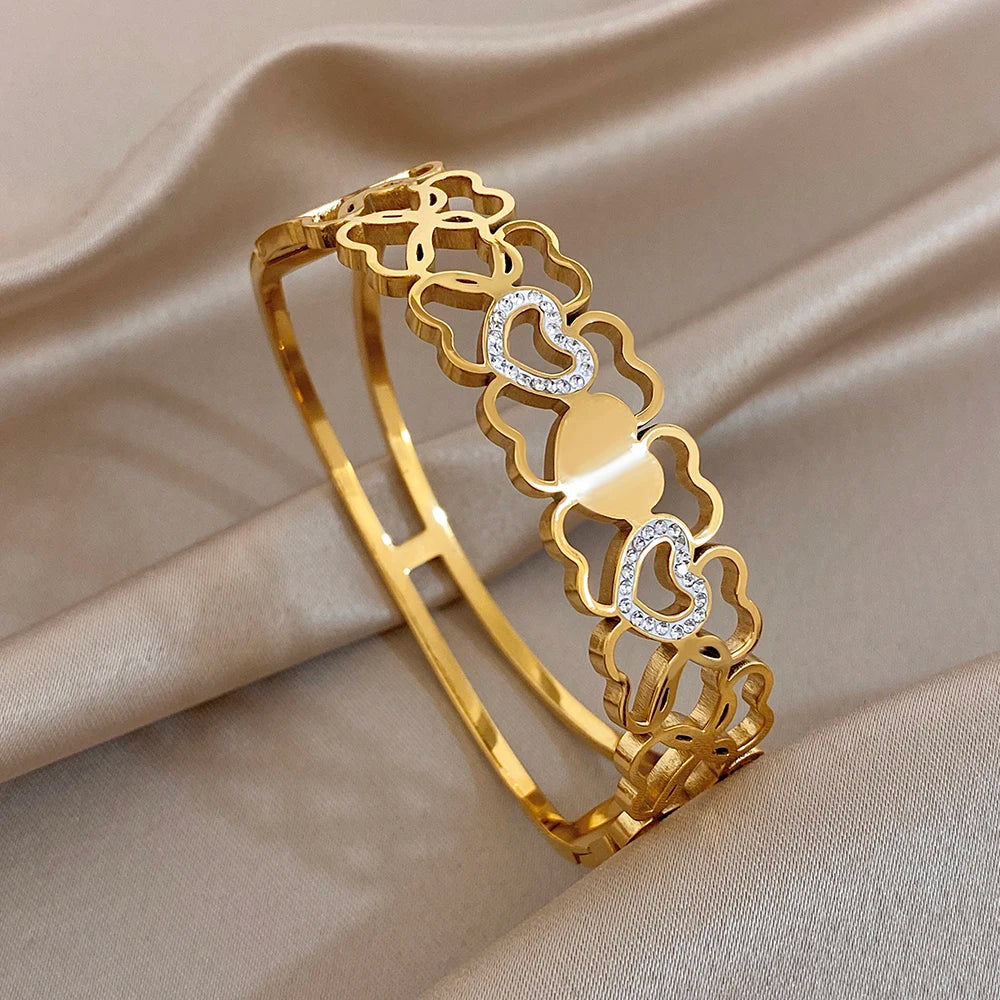 Gold cuff bangle with hollow heart patchwork and clear rhinestone heart accents