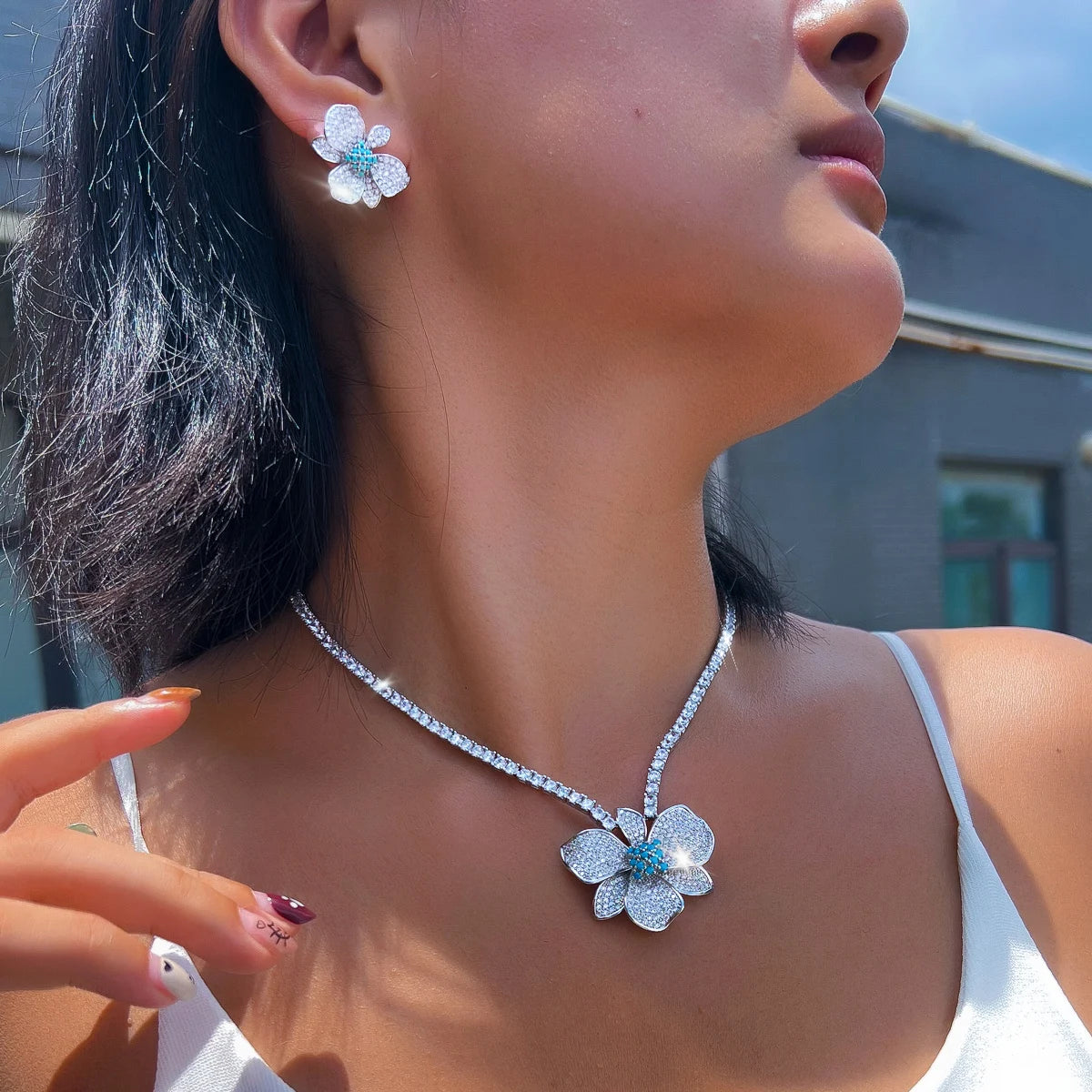 Silver-tone flower crystal necklace and matching stud earrings worn together
