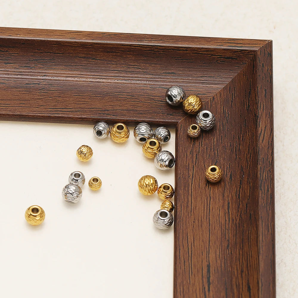 Small pile of striped cut flower spacer beads in gold and silver on wood display