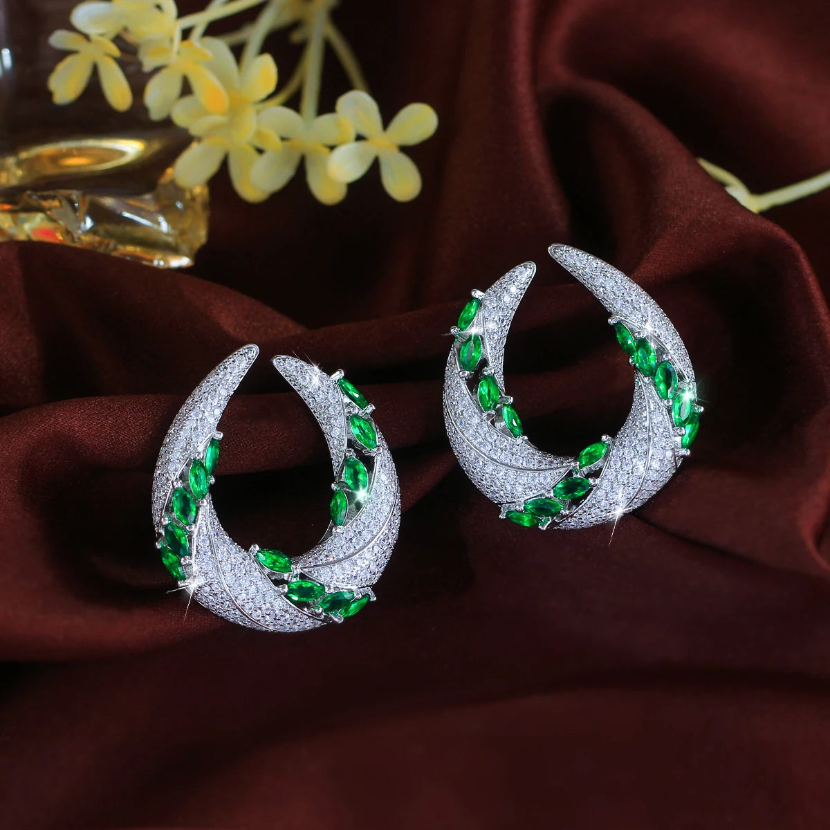 Geometric cubic zirconia drop earrings with green stones and white pavé crescent hoops