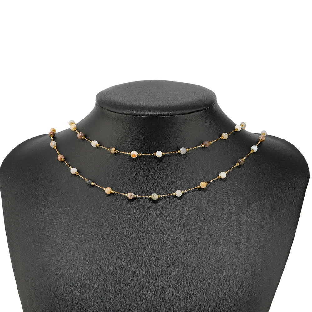 Gold-link gemstone bead necklace with multicolor stone beads on a black mannequin bust