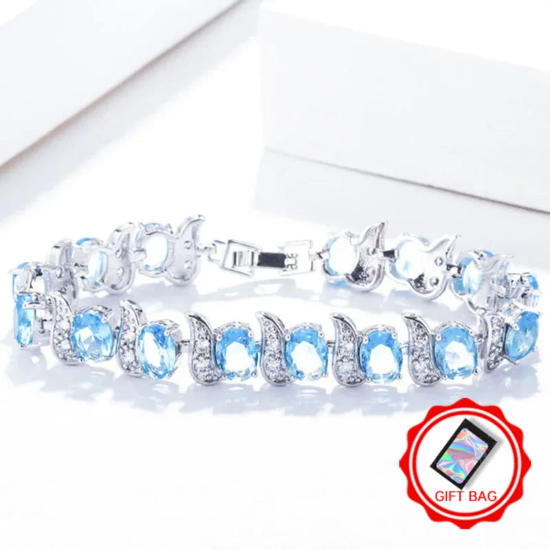 Light blue oval crystal tennis bracelet with silver-tone leaf accents and clasp