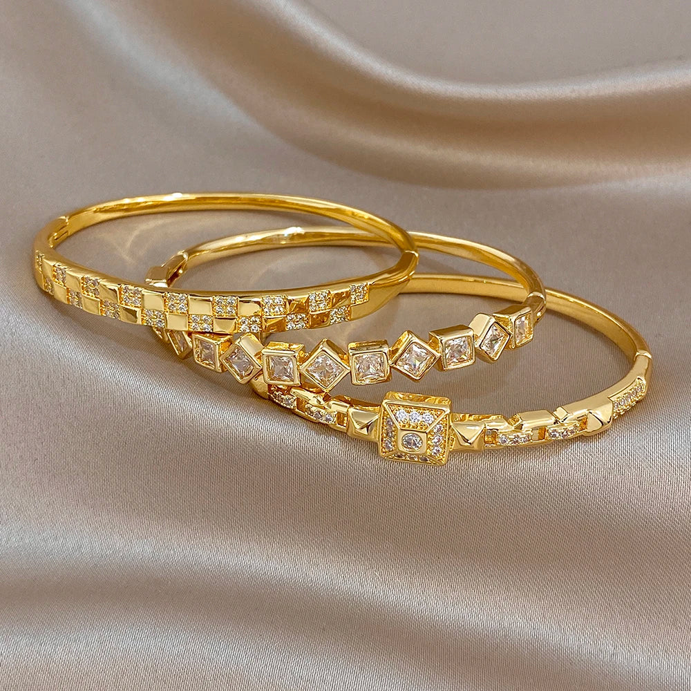 Pair of gold-plated cuff bangles with square zirconia link detailing and central square