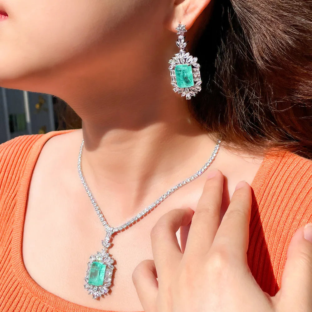 Cubic zirconia jewelry set with teal square stones, silver-tone necklace and earrings