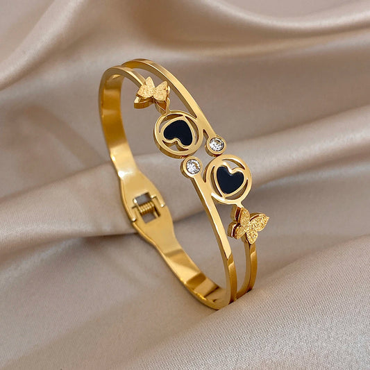Gold-tone heart and circle butterfly cuff bangle with black enamel and crystal accents