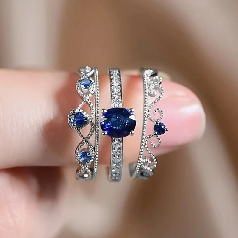 Silver-tone CZ ring set with blue oval center stones and heart cutout details