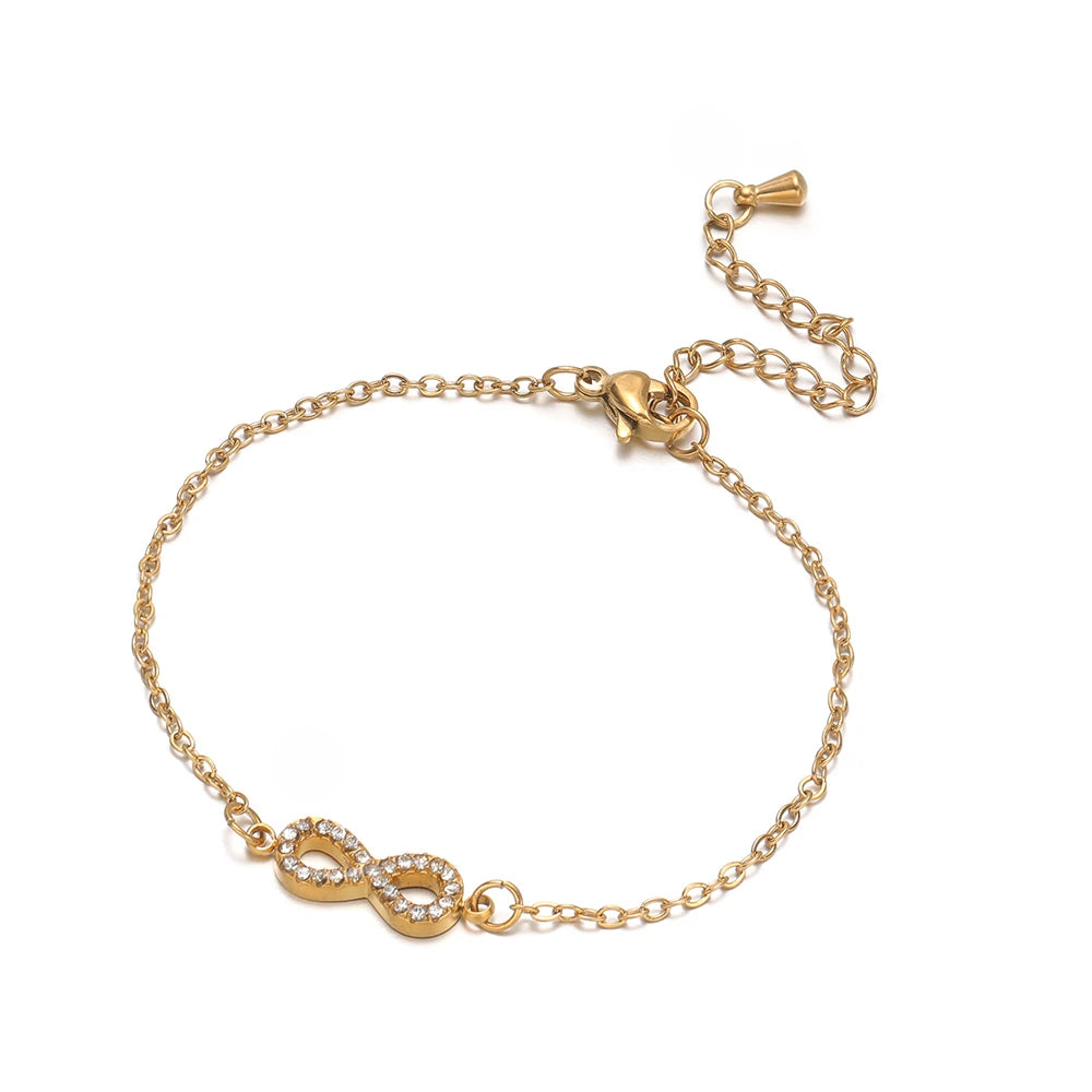 Gold-tone flat link adjustable bracelet with extension chain and infinity charm centerpiece