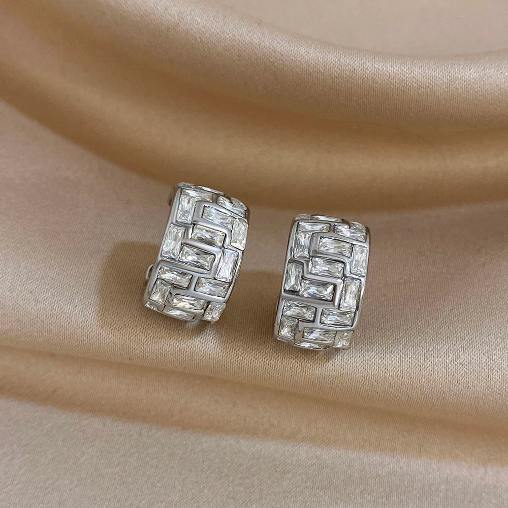 Silver-tone geometric hoop earrings with clear stones in a maze-like pattern