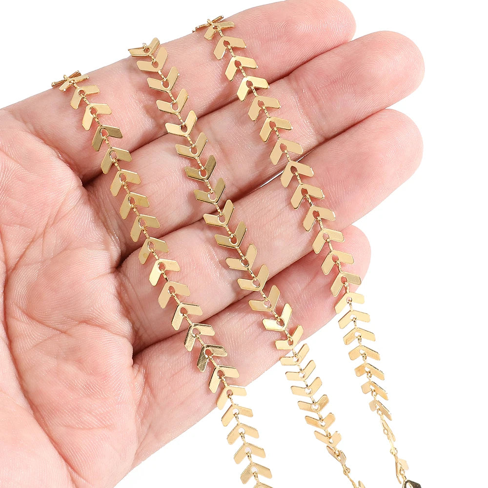 Gold airplane arrow link chain held in hand, showing small glossy connector bars