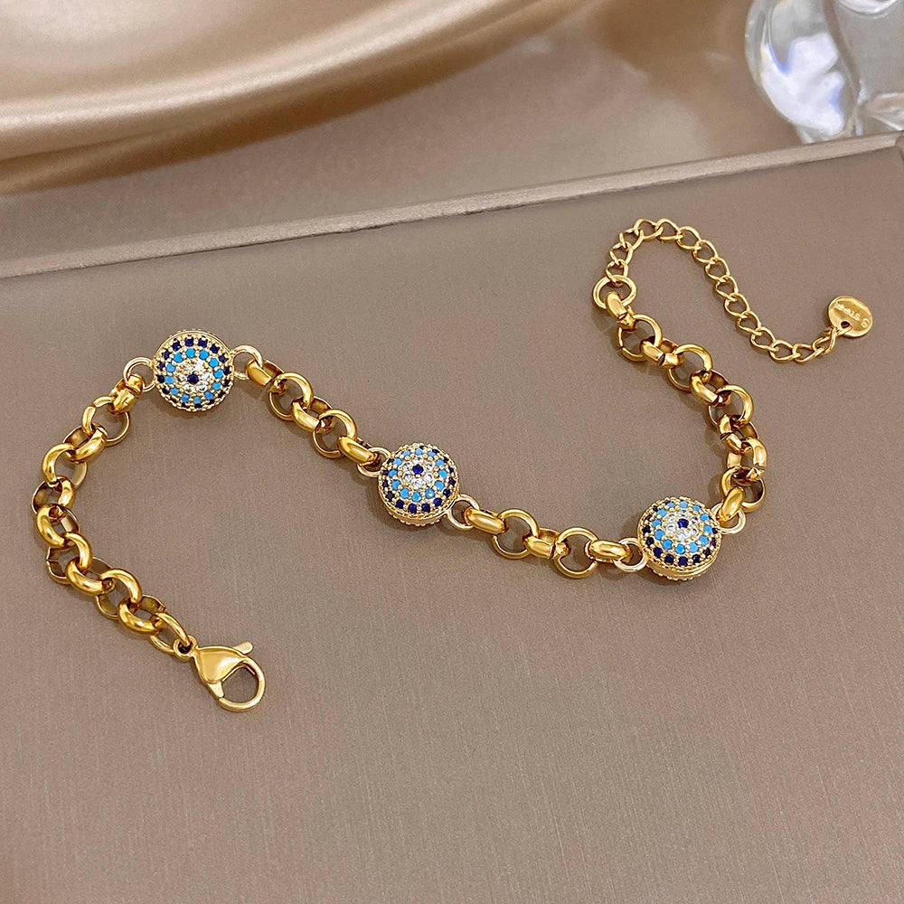 Gold-tone chain bracelet with blue evil-eye bead charms and adjustable link chain