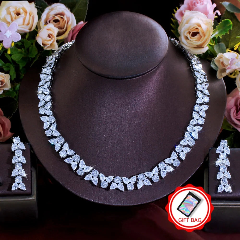 Clear zirconia leaf necklace and matching dangling earrings displayed on a jewelry stand