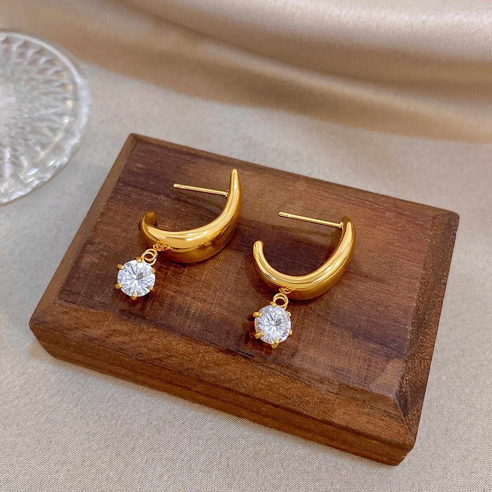 Gold-tone hoop earrings with dangling clear round crystal charms