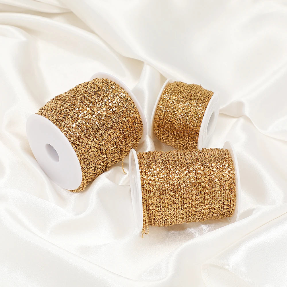 Gold plated flat flower chain rolls on spools, textured glitter-like linked chain