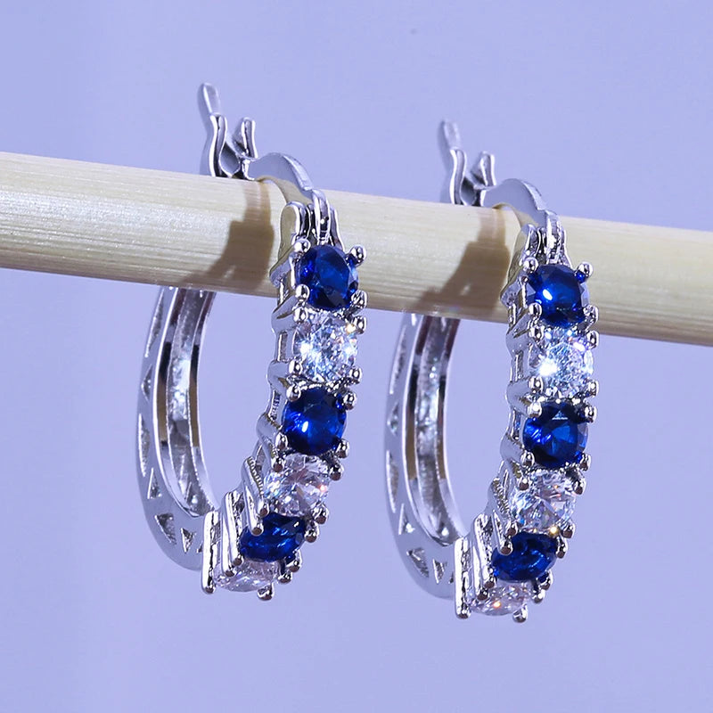 Silver circle hoop earrings with blue and clear gemstone clusters