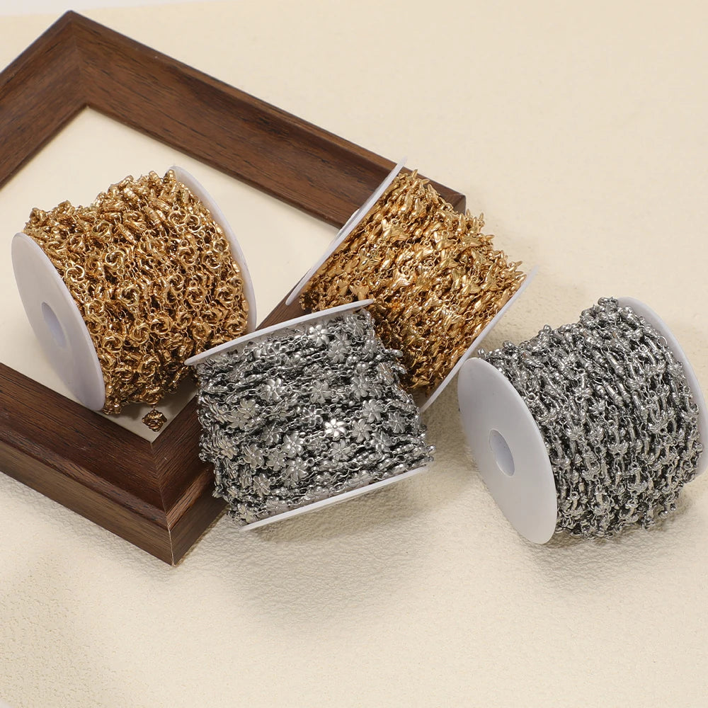 Gold and silver sea-animal charm chain rolls in a wooden organizer for jewelry making