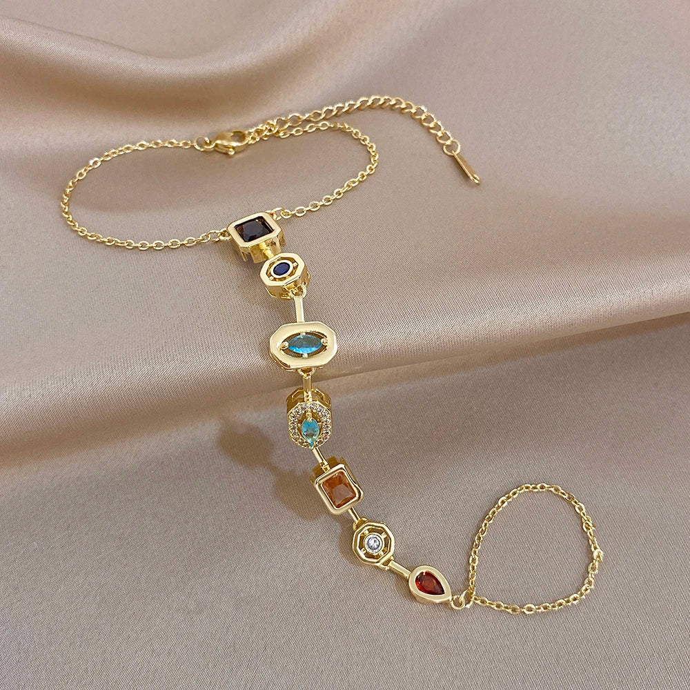 Gold-tone geometric zircon bracelet with colorful hanging stones and round finger-chain ring