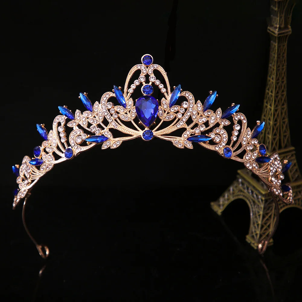 Jeweled bridal tiara crown with blue gemstones and red accents, ornate silver floral scrolls