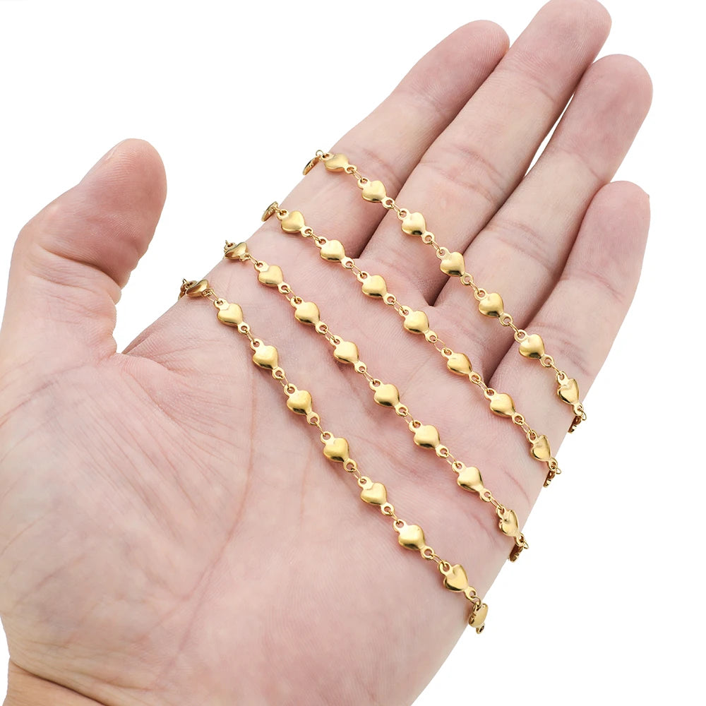 Gold heart chain links across an open palm, small heart-shaped connectors