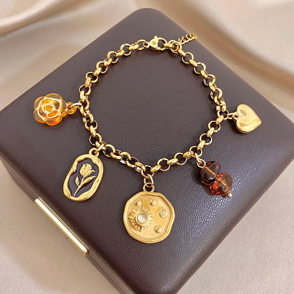 Gold chain bracelet with flower, tulip-style leaf, coin charm, heart clasp, amber drops
