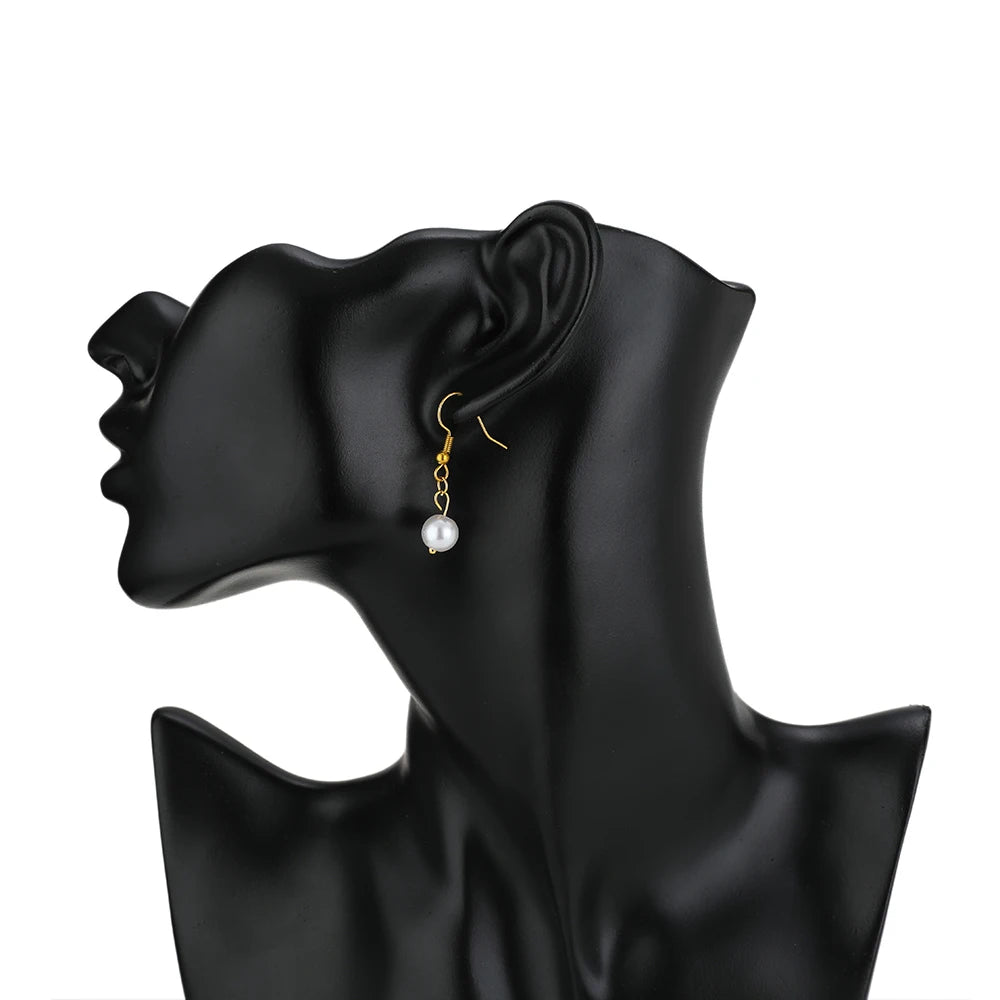 Pearl dangle earrings featuring gold ball head pins and curved hook wires