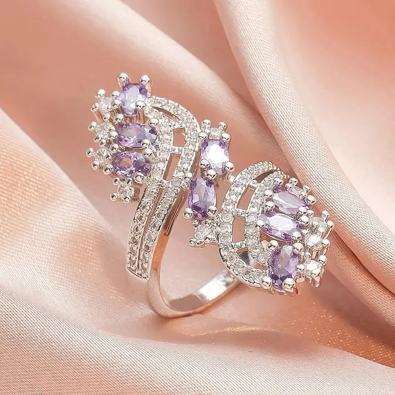 Rose-gold bridal cubic zirconia ring with purple oval stones and curved halo bands