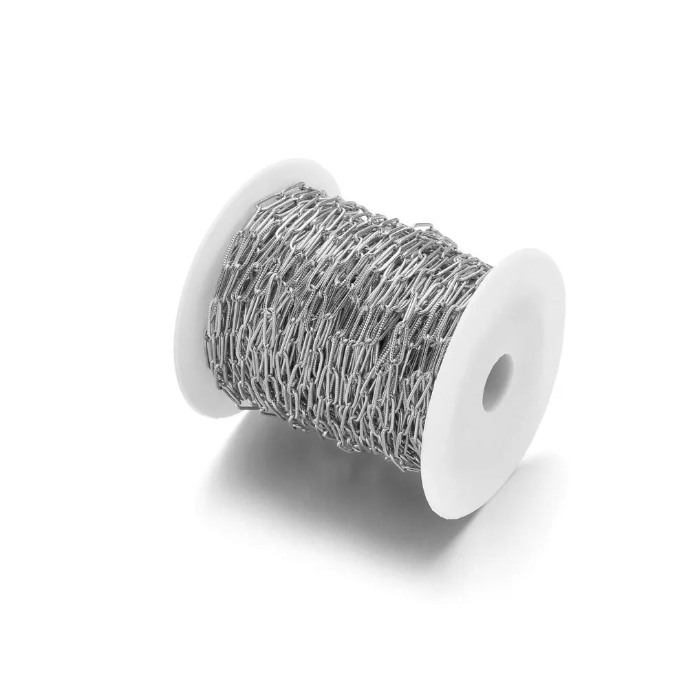 Silver-tone oval flat cable chain on a spool, cross/paperclip style links