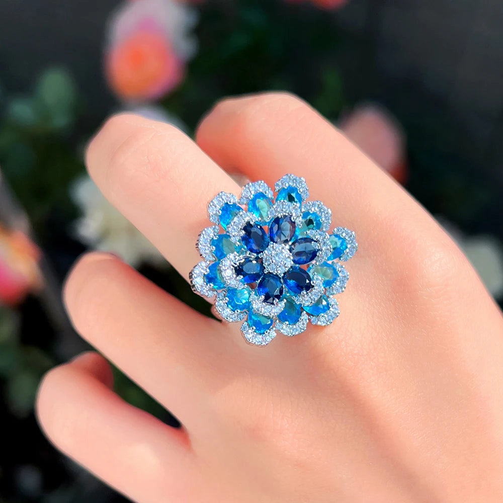 Close view of a blue floral statement ring with layered sparkling stones