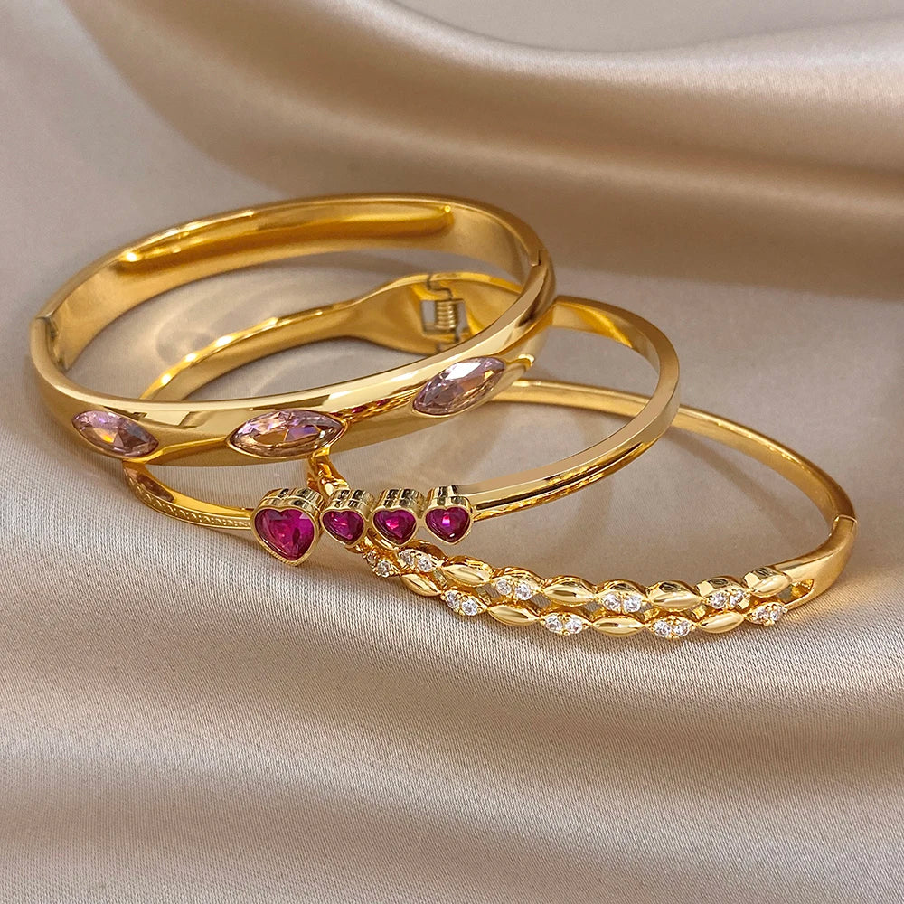 Gold tone stackable bangles with pink oval and purple heart zircon stones