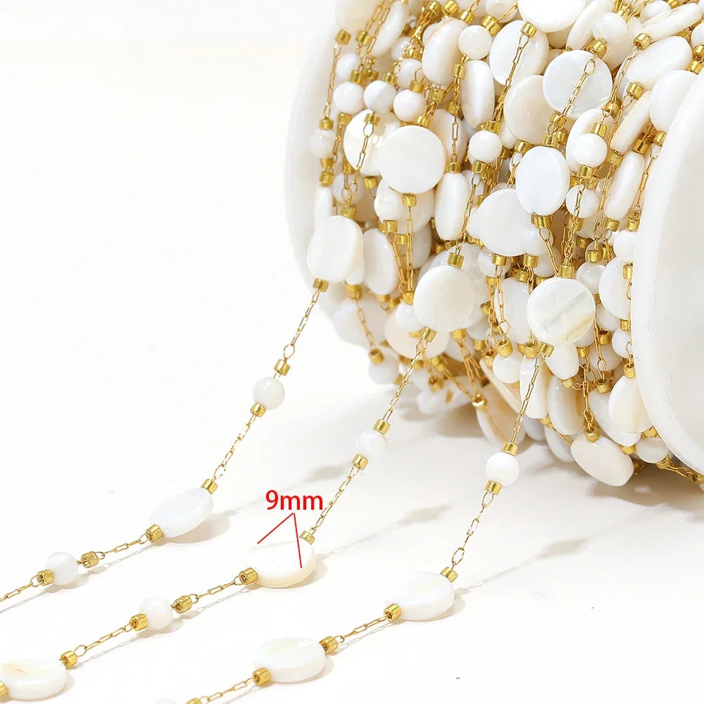 Shell bead jewelry chain: white cross-and-oval shells on gold-tone links (9mm marked)