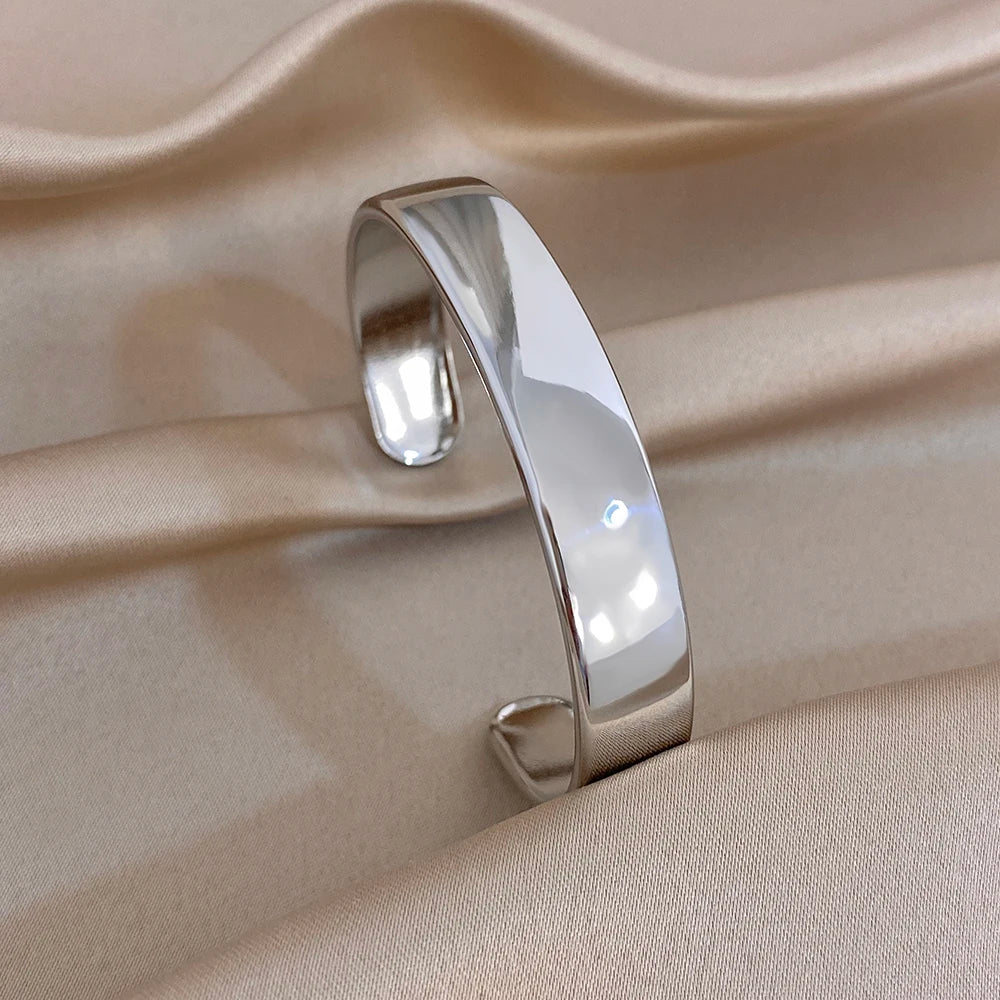 Silver glossy chunky cuff bangle with smooth reflective wide band