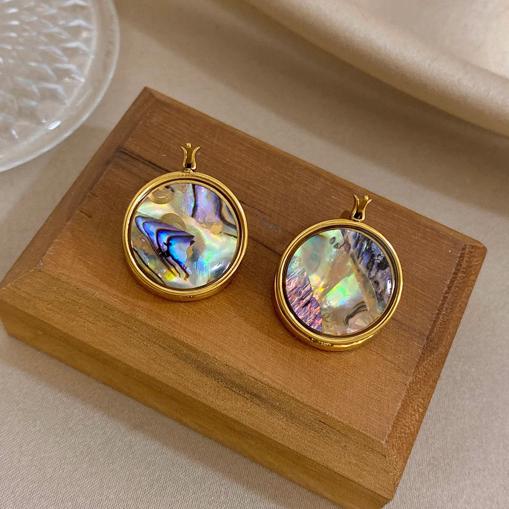 Round iridescent abalone shell hoop earrings with gold finish, pair on display