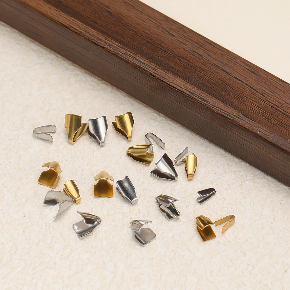 Scattered gold and silver crimp end caps with folded tips for cord ends