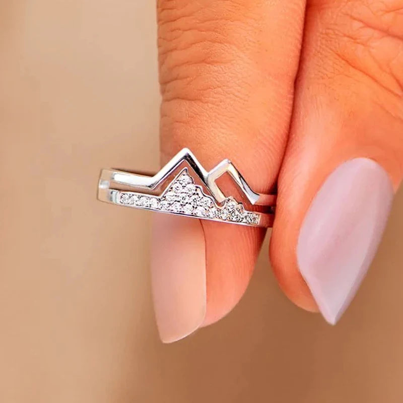 Silver-tone mountain-shaped cubic zirconia ring on finger, horizontal top bar