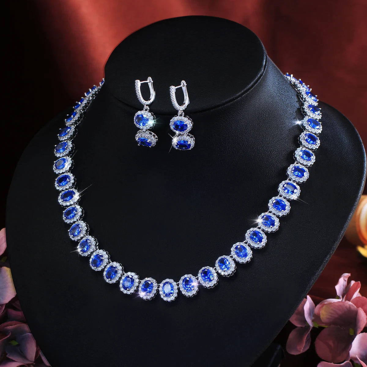 Royal blue cubic zirconia jewelry set on mannequin: matching necklace and drop hoop earrings