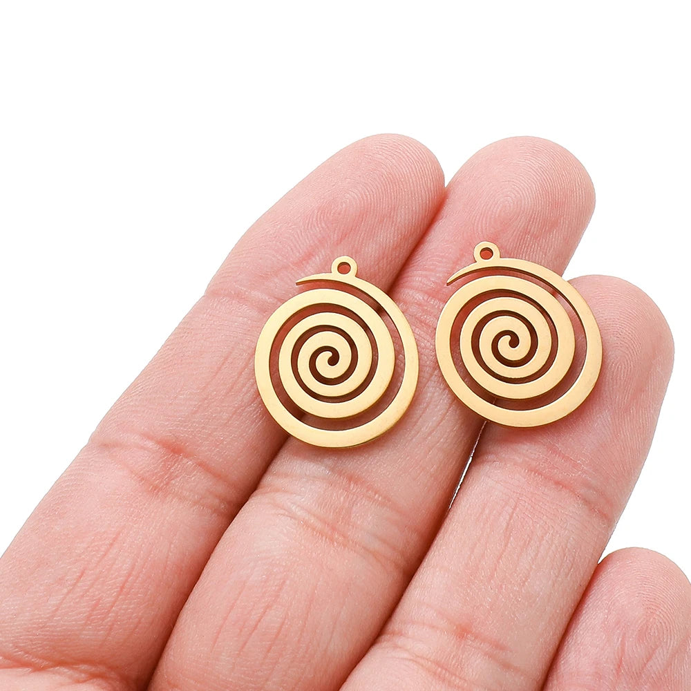 Gold spiral round charm pendants with loop bail, held in fingers, swirl pattern