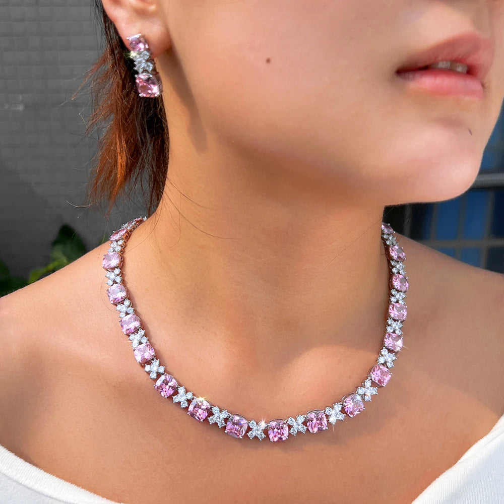 Pink square zirconia necklace with matching drop earrings, shown on model neckline
