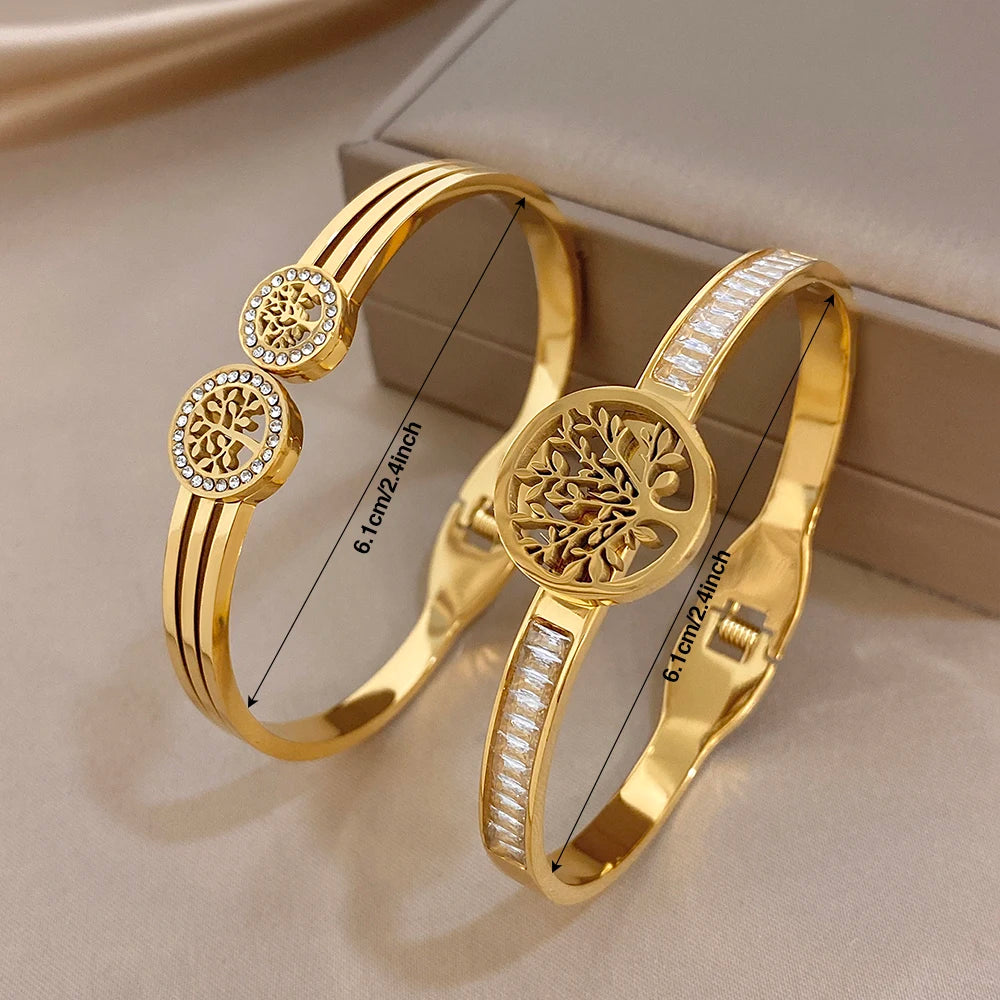 Gold-tone cuff bangles with tree-of-life medallion, round zircon details, hinged clasp