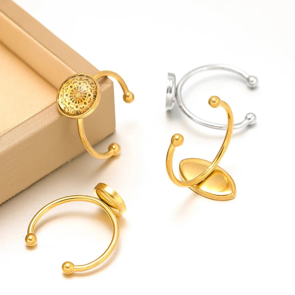 Assorted gold and silver open cabochon ring settings with round blank trays and ball prongs