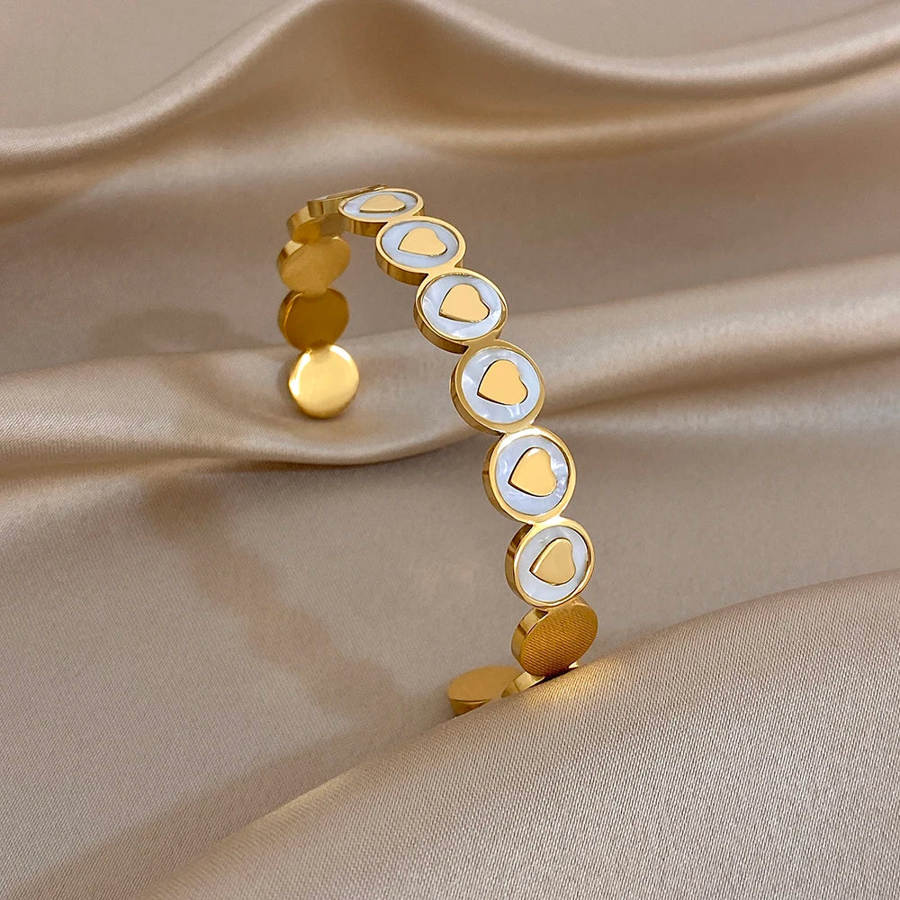 Gold-plated cuff bangle with white heart inlays and round link accents