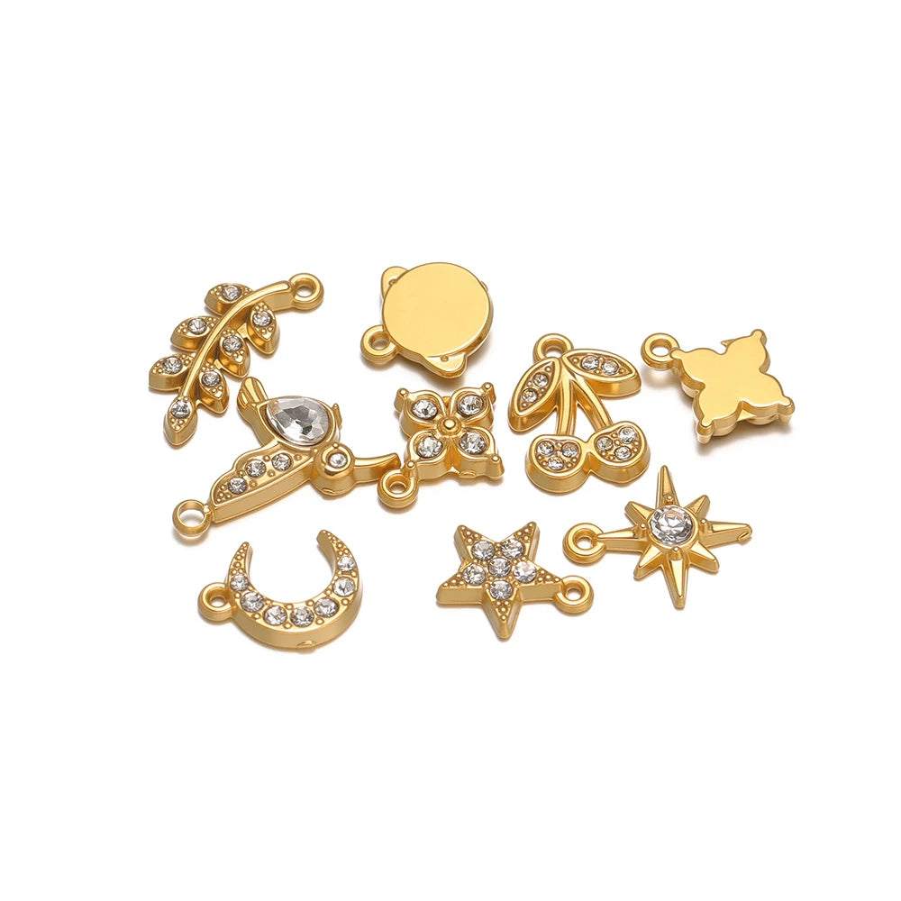 Assorted gold-tone rhinestone charms with loops, including moon, star, clover, bird, cherry