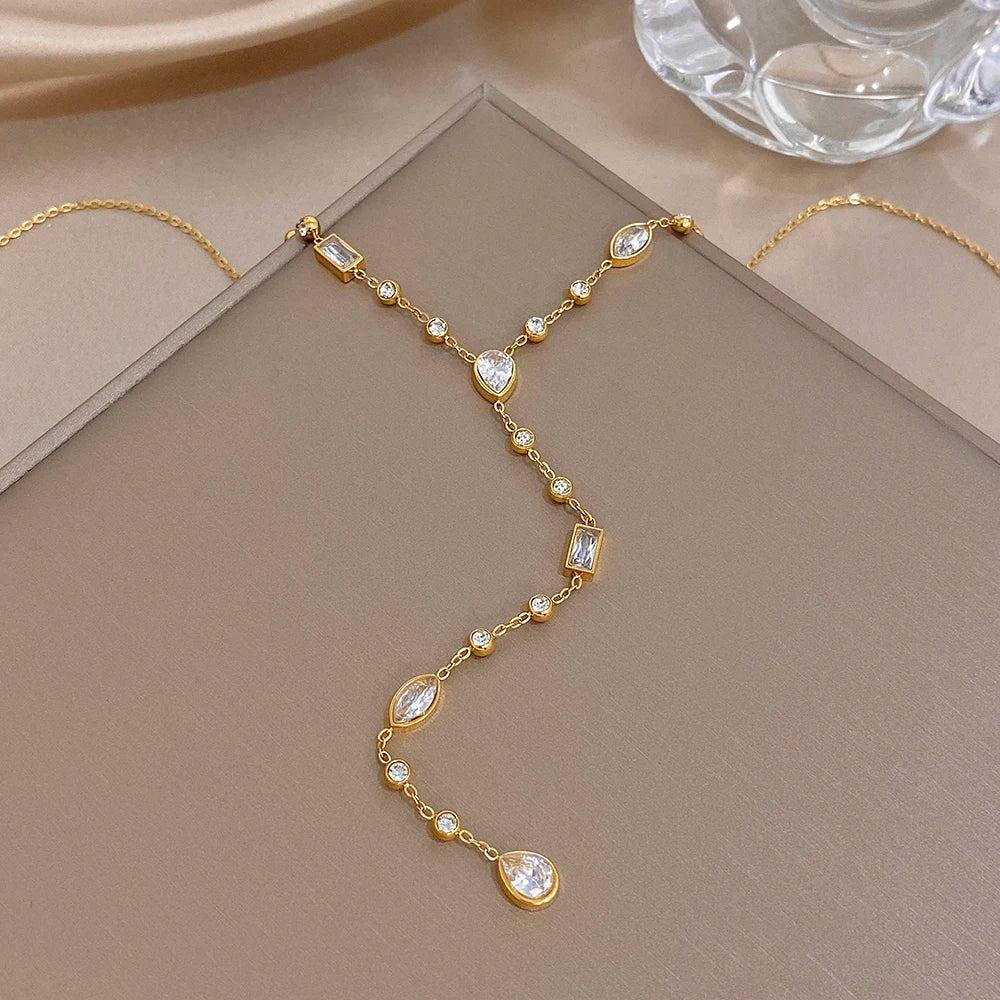 Gold-tone Y choker necklace with faceted oval crystal drop and small bead links