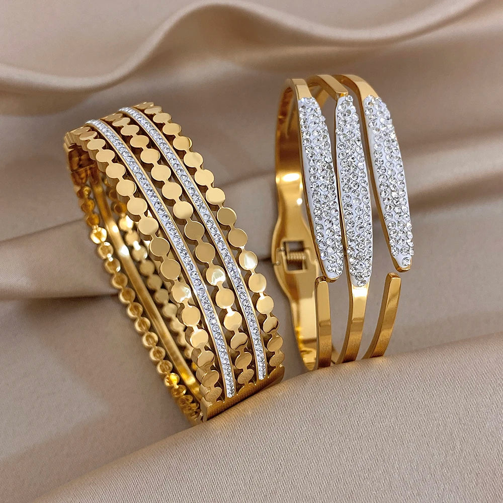 Gold-tone wide cuff bangles side by side with textured links and rhinestone inlaid bands