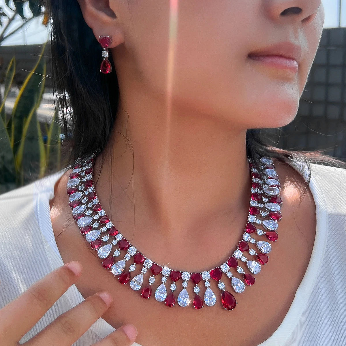 Red and clear rhinestone teardrop choker necklace with heart drop earrings, close-up