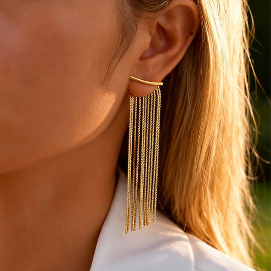 Gold long chain fringe tassel earrings worn on a model's ear
