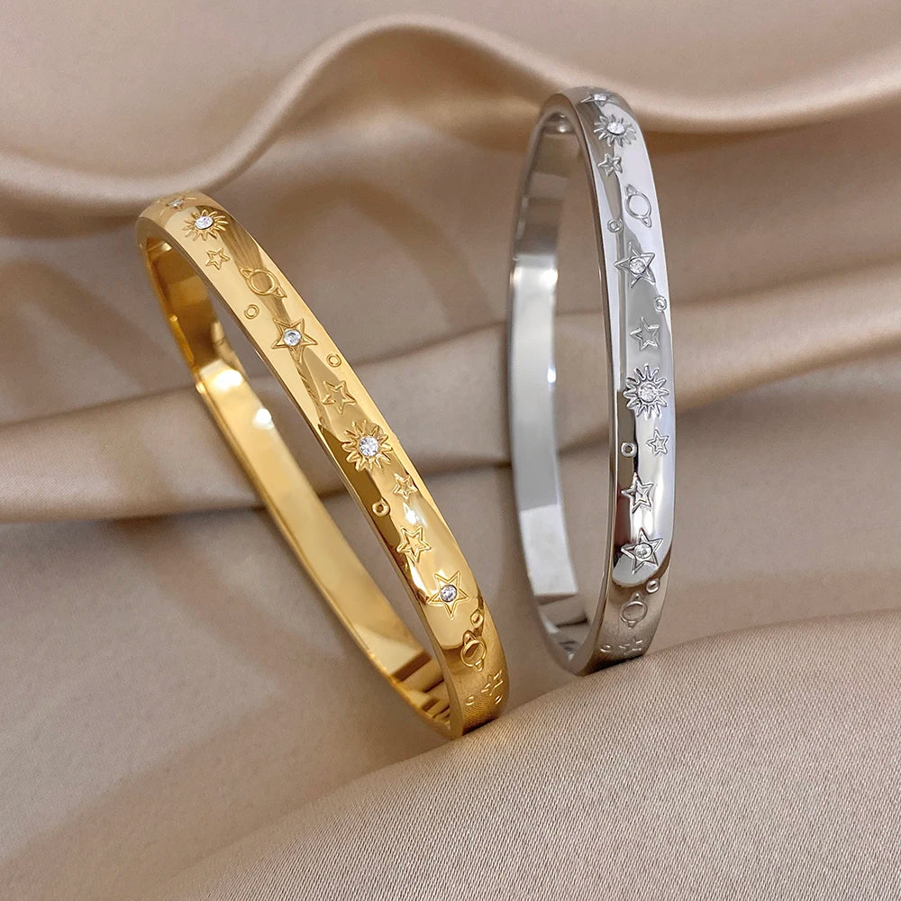 Gold-tone wide stainless steel cuff bangle with engraved star and rhinestone accents