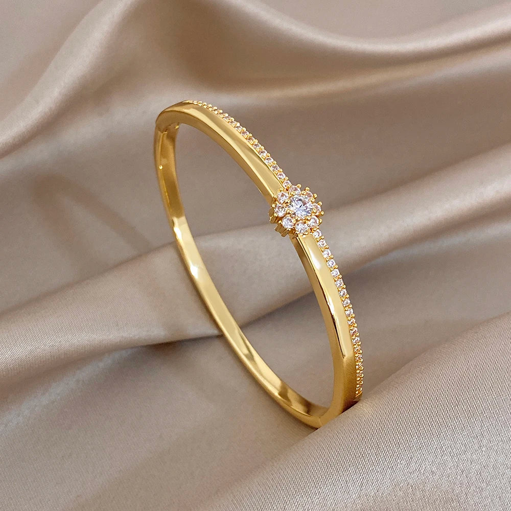 Gold-plated cuff bangle with zircon flower cluster along micro-inlaid band