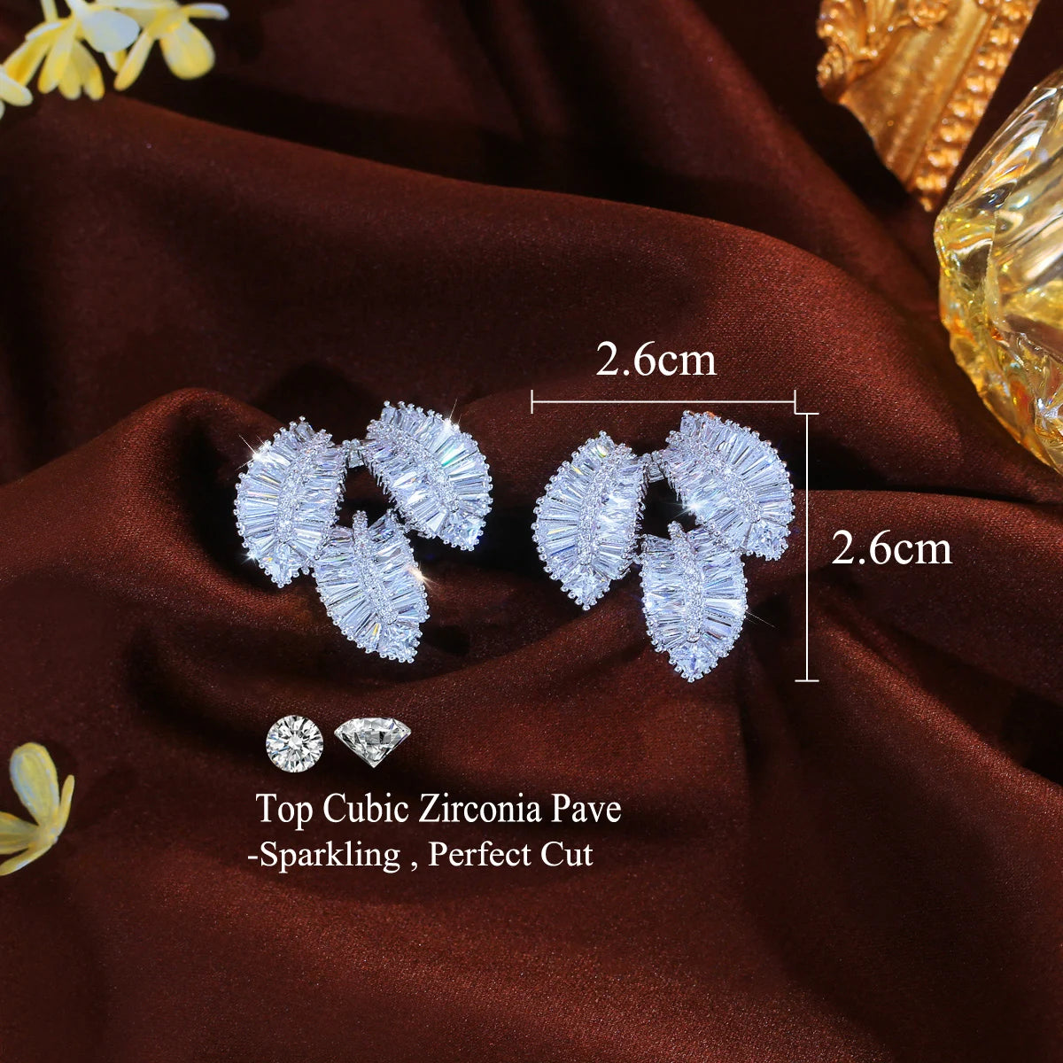 Pair of silver-tone cubic zirconia leaf earrings, each about 2.6 cm wide and long.
